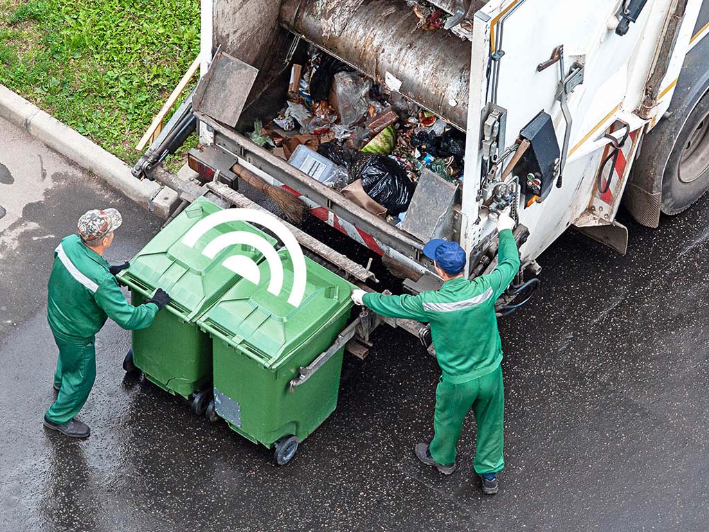 Garbage handlers empty smart waste bins that send signal when they need to empty a garbage truck